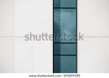 An abstract close-up of a section of a modern building showing a vertical window.