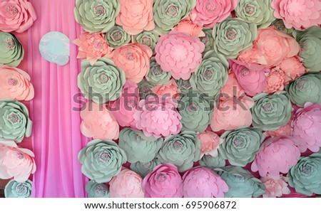 Photozone with large pink, coral and gray paper flowers and pink cloth, free space. Wedding or holiday photozone, texture background