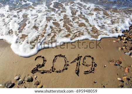 New year 2019 written in sand.