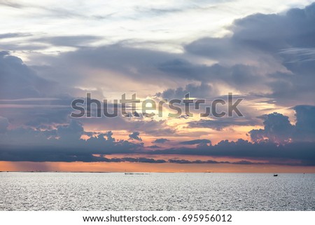 Natural sunset sunrise and light rays over tropical sea in twilight period . Bright dramatic Sky at horizon on the beach .The power of the Sun and nature concept.Toned warm pastel colours photo.