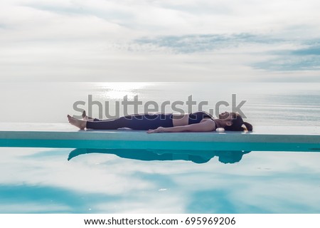 Vacation of Beautiful Attractive Asian woman relaxing in yoga Savasana pose on the pool above the beach with beautiful sea in Tropical island,Feeling comfortable and relax in holiday,Vacations Concept Royalty-Free Stock Photo #695969206