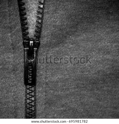 Close up shot of hoodie sweatshirt in detail with zipper, textile surface with vintage filter in square format