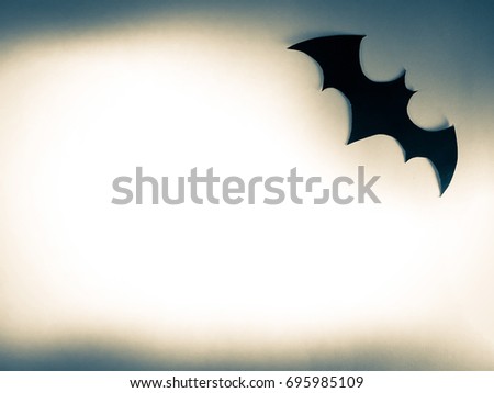 Big flying black bat paper cutting is decorated on dark vintage background for Halloween festival.