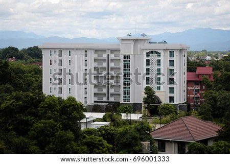 White buildings in the city amidst trees and mountain views.