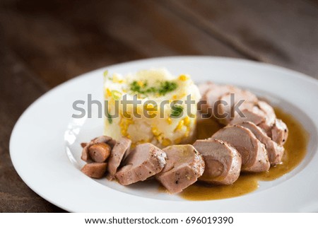 Fillet Pork tenderloin spiced with spicy sausage, mashed potatoes with corn and onion