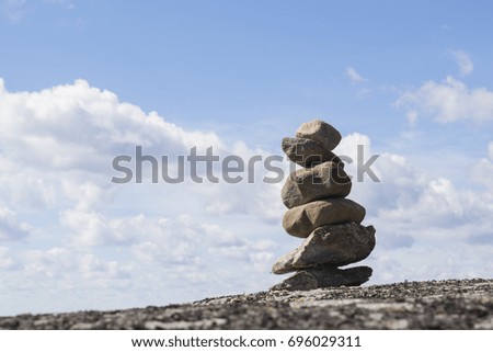 Concept of balance, stone pyramid standing on a rock. 