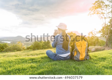Female tourists Take a photography on the mountain at sunset.