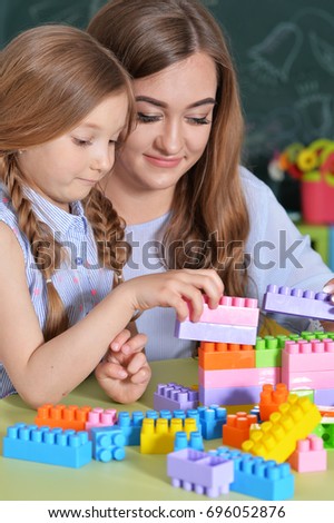 Mother and daughter playing with plastic blocks