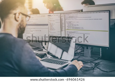 Developing programming and coding technologies. Website design. Programmer working in a software develop company office. Royalty-Free Stock Photo #696061426