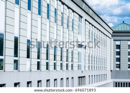Modern office buildings in the city with reflection of other building in blue glass windows and glass wall ,with white clouds