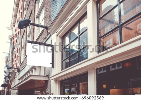 Mockup of signboard at the wall of the building on city street. Mockup could be used for presenting logotypes of shops, barber shops, bars, restaurants, cafe and others. Urban syle concept