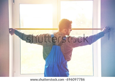 service man installing window with measure tape Royalty-Free Stock Photo #696097786