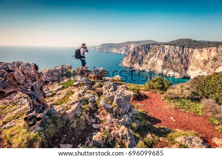 Photographer take picture on the top of cliff over the Ionian Sea. Sunny morning seascape of Zakynthos (Zante) island, Greece, Europe. Beauty of nature concept background.
