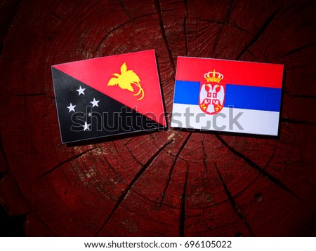 Papua New Guinea flag with Serbian flag on a tree stump isolated