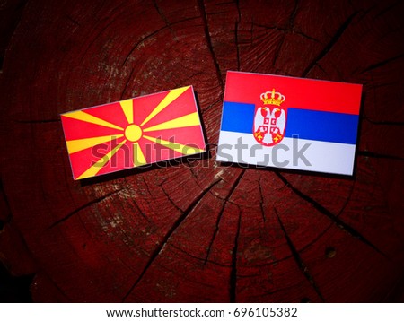 Macedonian flag with Serbian flag on a tree stump isolated