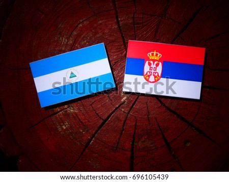 Nicaraguan flag with Serbian flag on a tree stump isolated