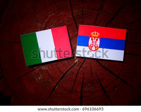 Italian flag with Serbian flag on a tree stump isolated