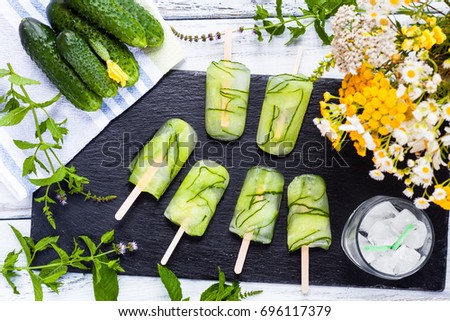 Homemade organic vegan green cucumbers popsicles. Refreshing Healthy lifestyle diet Ice pops on rustic white wooden background. Dessert ice cream for lose weight. Top view. Detox concept. Clean food.
