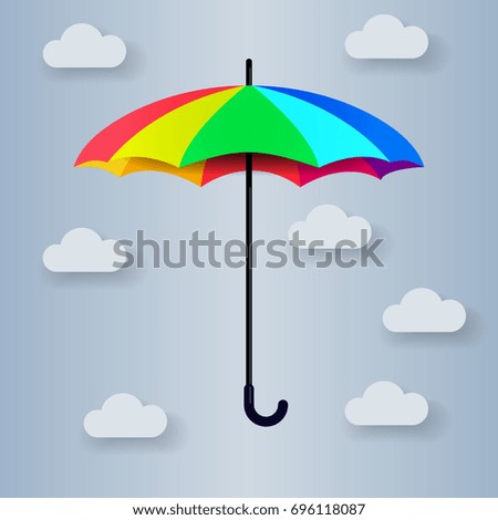 Multi-colored umbrella on a gray background with clouds