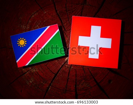 Namibian flag with Swiss flag on a tree stump isolated
