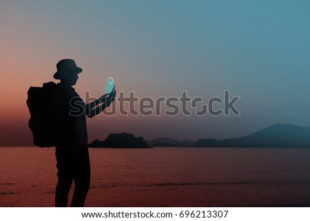 Mobile Internet for Travelling Concept, Silhouette of Traveler using smart phone to Connect or Find Place via Network, Beach or Lake as background
