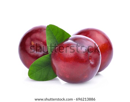 three whole of cherry red plum with green leaves isolated on white background