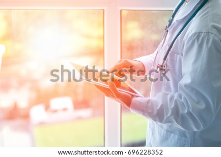 Professional medical physician doctor white uniform gown coat stethoscope hands holding digital patient chart information computer tablet in clinic hospital.Medical/ healthcare/ technology concept Royalty-Free Stock Photo #696228352