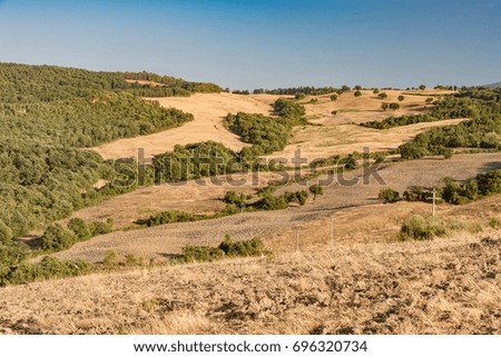 Panorama from mountain on desert in summer with yellow and brown colors of lands burned from the hot sun in Italy