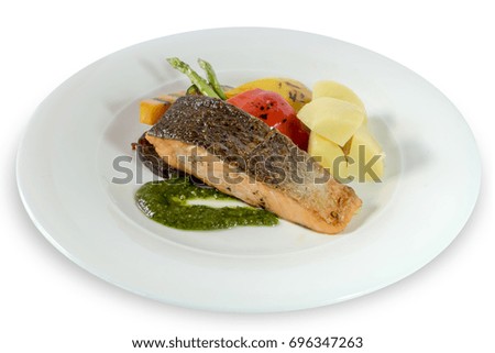 grilled salmon steak, grilled vegetables and pesto sauce on white background. clipping path