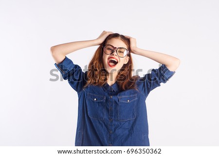 Cute teenage girl smiling with glasses holding her head against a light background                               