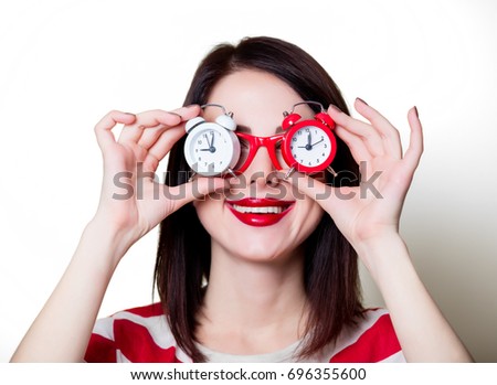 Portrait of a young woman in glasses with retro alarm clock