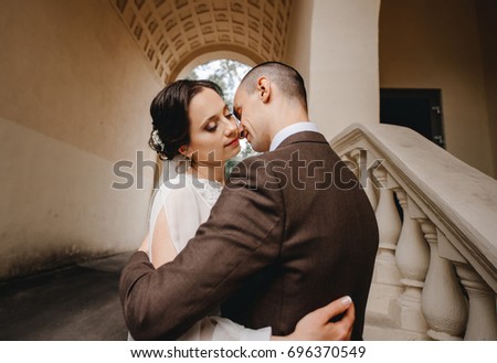 Gorgeous wedding couple walking in the old city. Kissing. Classical architecture