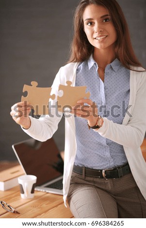 Business woman holding and pointing to a puzzle piece. Concept team. Woman. Puzzle.