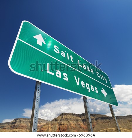 Road sign in desert pointing towards Salt Lake City and Las Vegas.