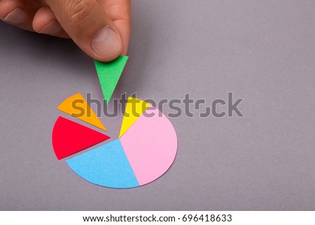 Round radial diagram with colored parts in the hands of a man on a gray background. Copy space for text