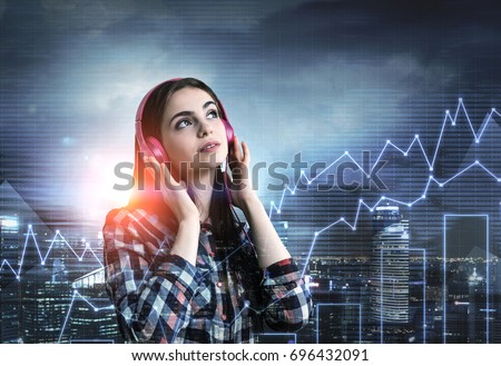 Portrait of a pretty young teenage girl wearing a checkered shirt and listening to the music with her bright dark pink headphones. She is standing in a city with graphs. Double exposure toned image
