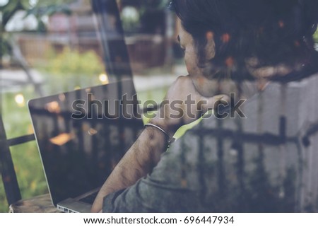 Dramatic serious moment with selective focus of Young businessman using tablet computer in classy coffee shop.Interior of coffee shop and customer using digital devices on free wifi internet service.