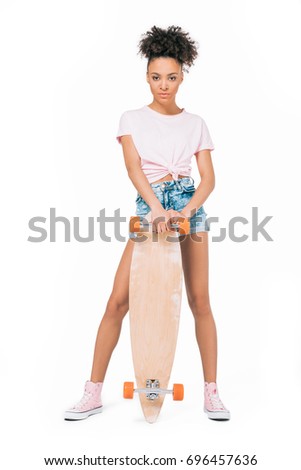 beautiful young african american woman posing with skateboard isolated on white 
