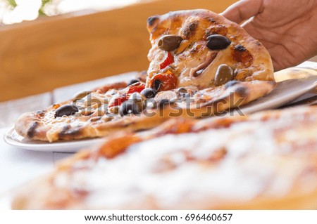 Shallow focus of pizza holding outdoors on table