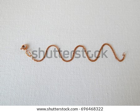 Golden bracelet in the form of a snake on a white background
