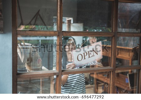 attractive asian business woman turning the open sign of her shop