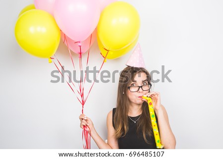 Young woman with party hat with noisemaker on a white background