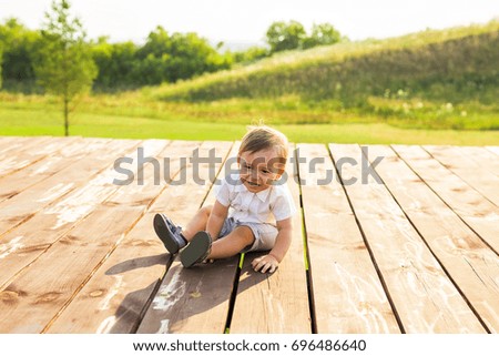 smiling boy in the field at sunny summer morning. boy in white shirt. The family travels, child happily ran around the field