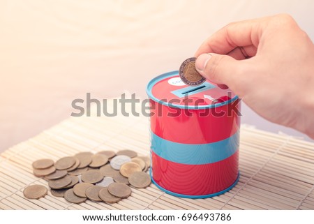the abstract image of hand put the coin in the piggy bank. The concept of financial, e-commerce, economizing and investment. Royalty-Free Stock Photo #696493786