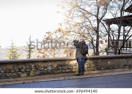 Travel, vacation, photographer and hitchhiker concept - traveler man photographed nature
