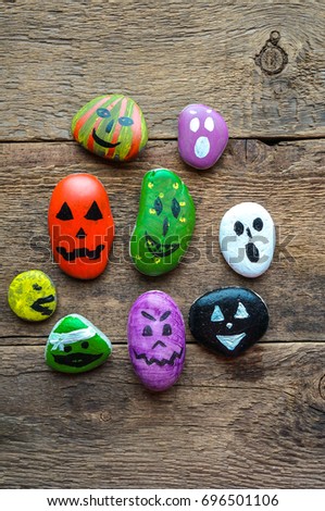 Halloween background with funny painted stones like ghosts, top view