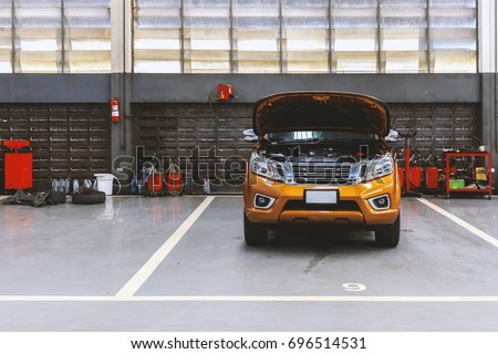 car in automobile repair service center with soft-focus in the background and over light Royalty-Free Stock Photo #696514531