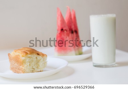 homemade tasty  pastry breakfast with glass of yogurt and watermelon slices placed on a white table