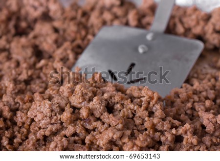 Cooked ground beef and a spatula in preparation for a meal
