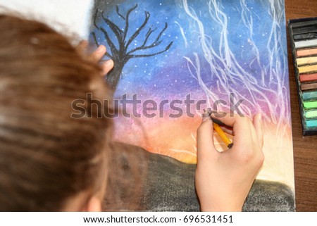 Teenage girl drawing using pastel crayon 